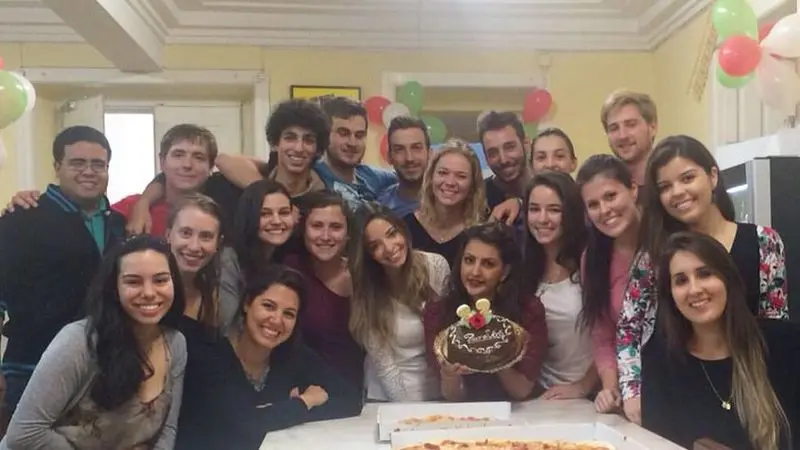 Residentes reunidos à volta de um bolo de aniversário