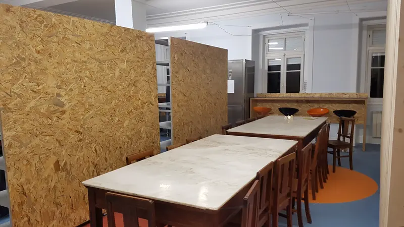 Sala de refeições com mesas compridas de mármore